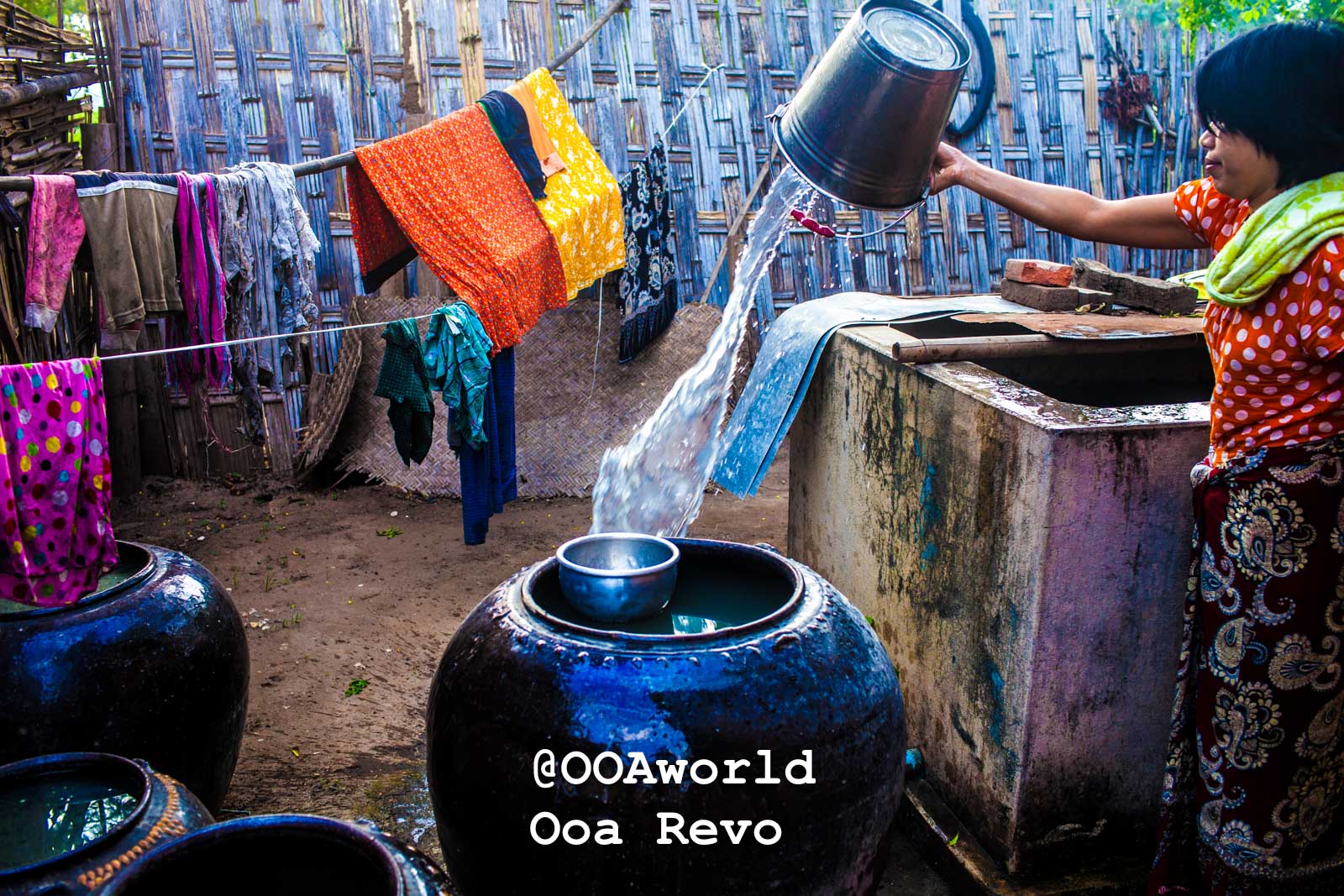 Bagan People Part I Bagan Woman pouring water into large jars colorful laundry drying Photo OOAworld
