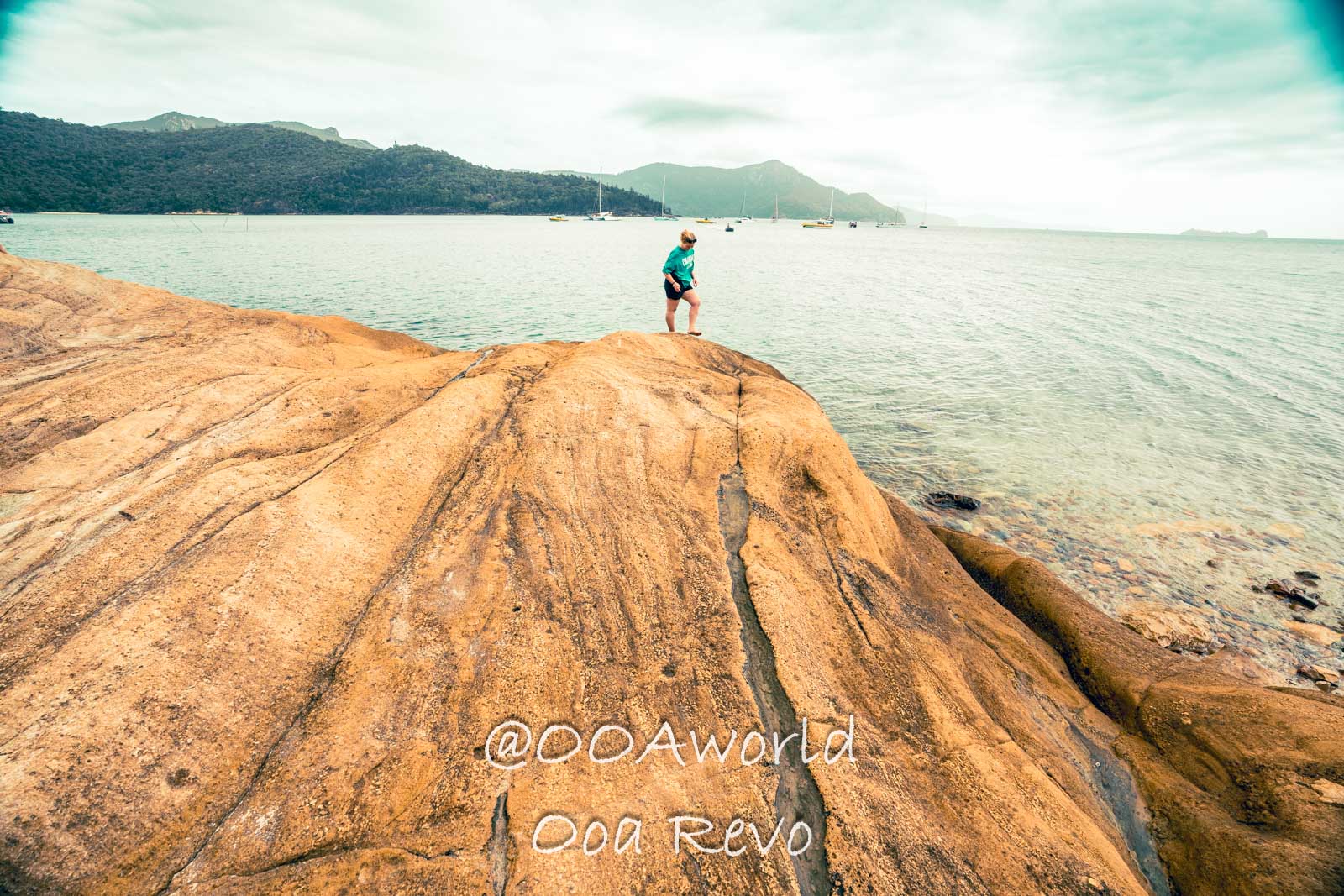 Airlie Beach Whitsundays Australia person standing on rocky coastline overlooking calm sea Photo OOAworld