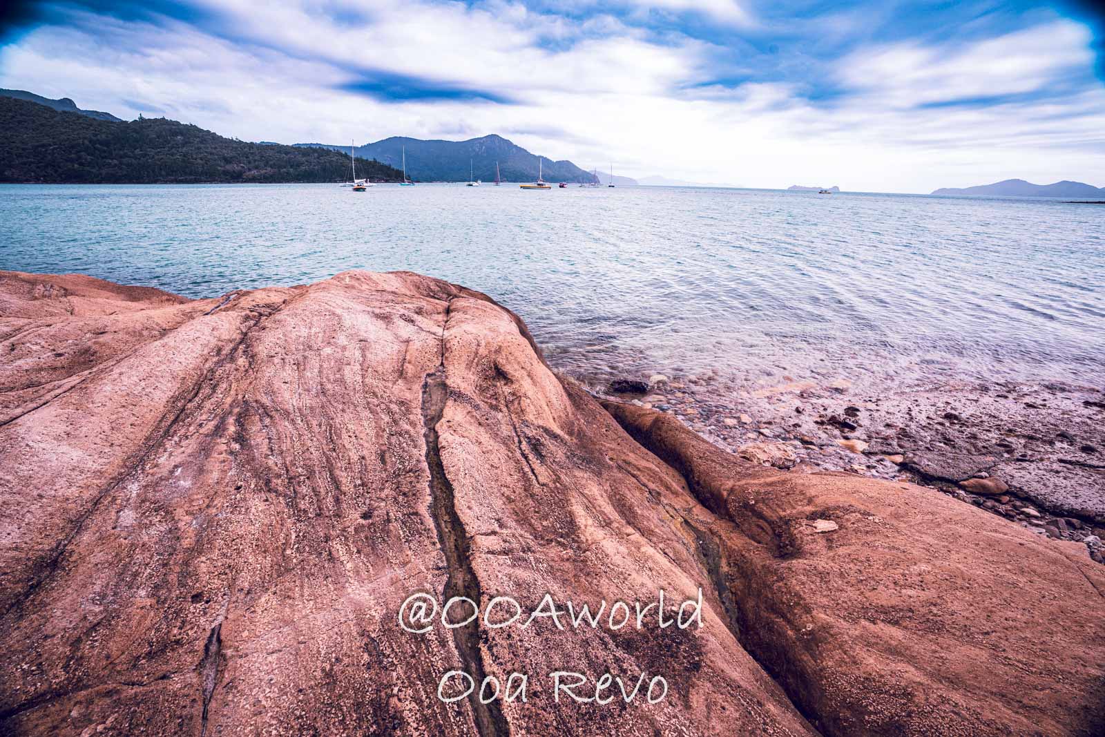 Airlie Beach Whitsundays Australia rocky beach landscape with ocean and sailboats Photo OOAworld