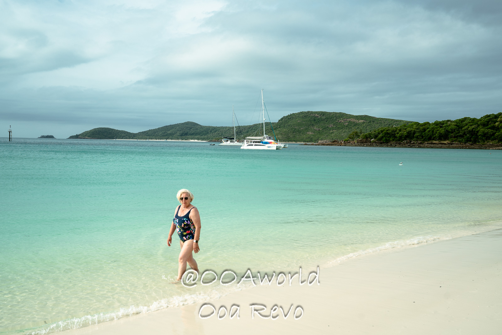 Airlie Beach Whitsundays Australia woman walking on tropical beach with sailboats in background Photo OOAworld