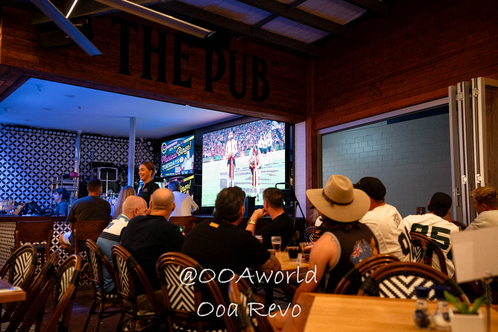 Airlie Beach Whitsundays Australia people watching sports on big screen at pub Photo OOAworld