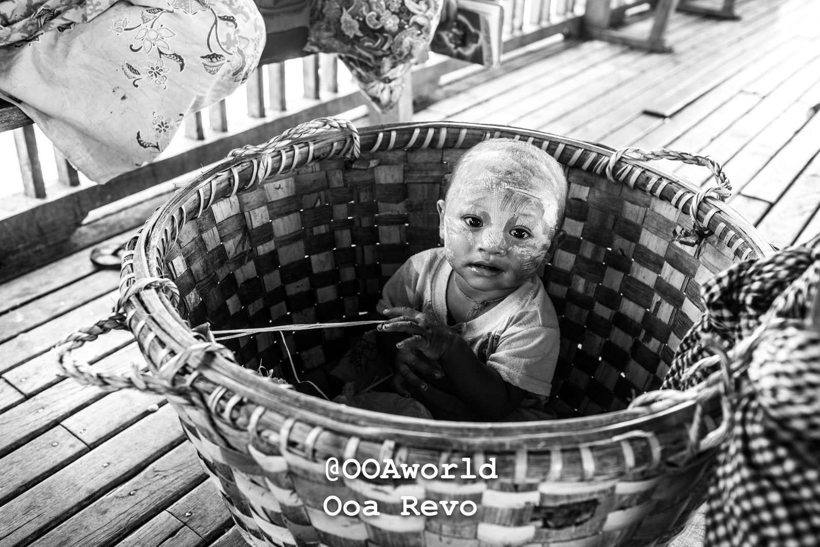 Amapura Myanmar Child in woven basket with painted face Photo OOAworld Amapura Myanmar Black and white photo of a child with painted face sitting in a woven basket Photo OOAworld