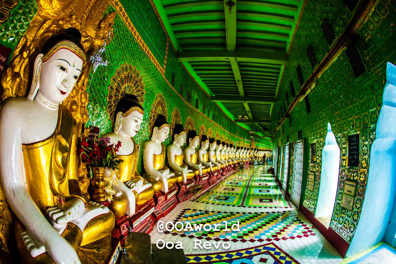 Row of Buddha statues in Myanmar temple with vibrant green and gold decor Photo OOAworld