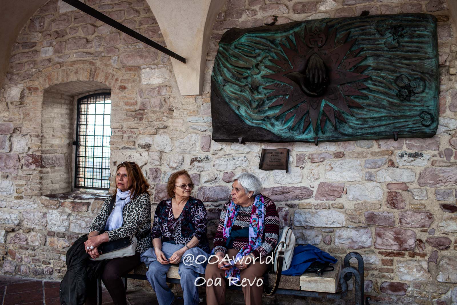 three women sitting on bench in historical stone building Italy Photo OOAworld