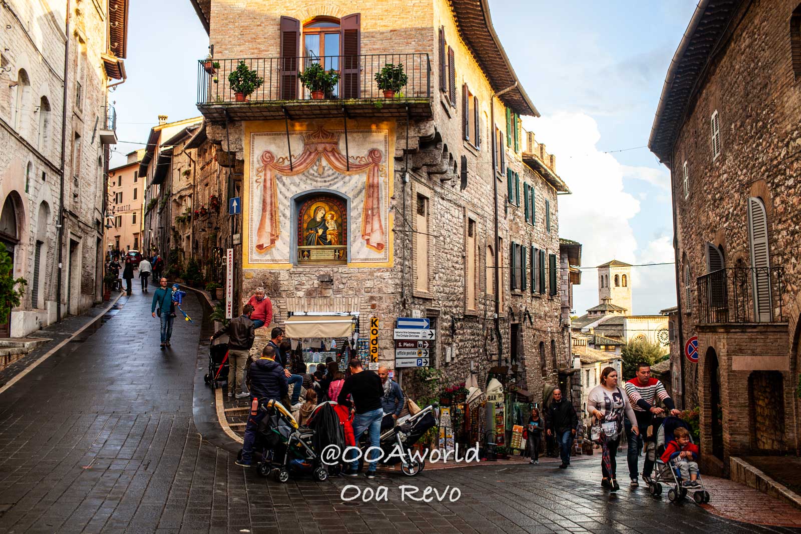 Street scene in Assisi Italy with historic buildings and people Photo OOAworld