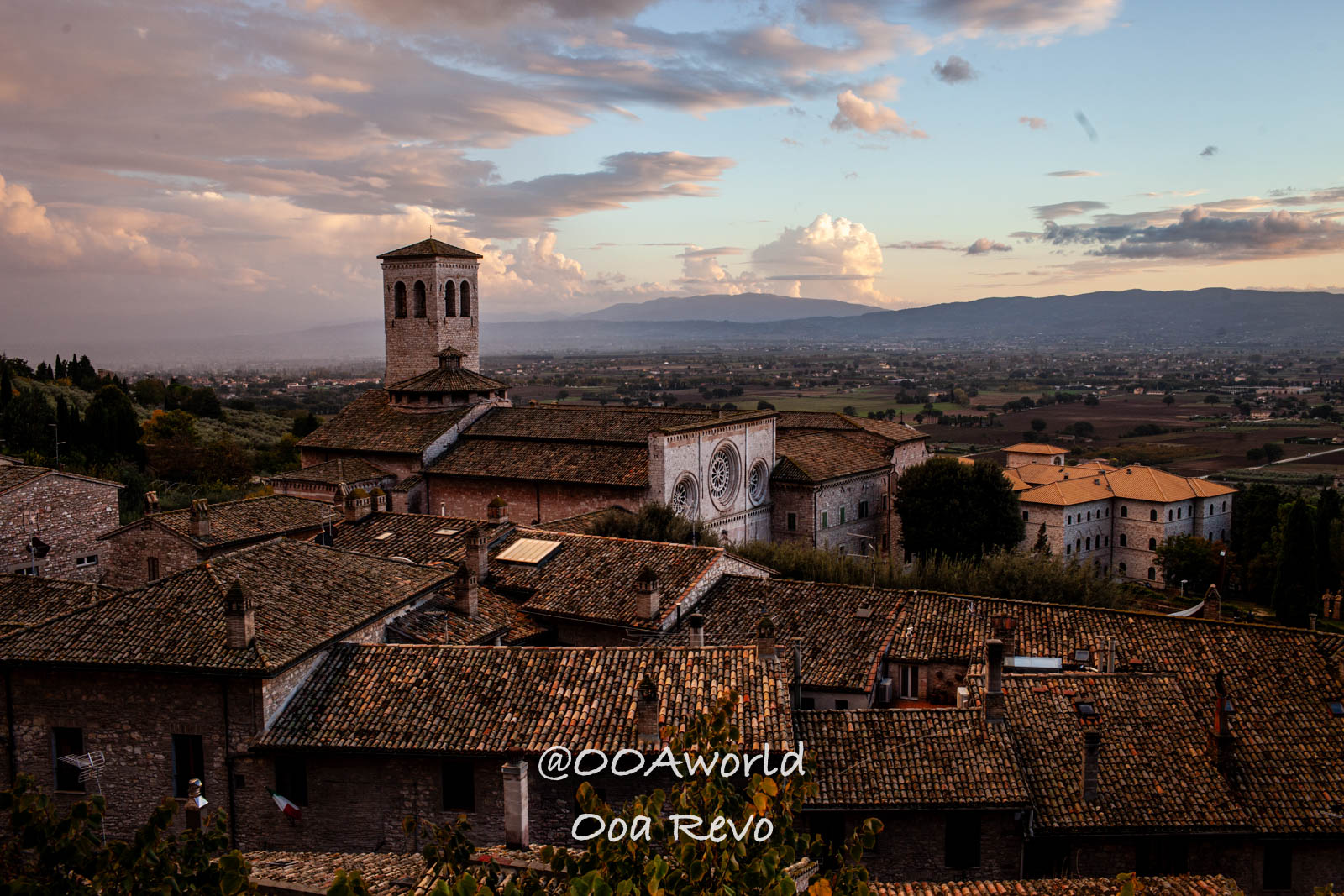 Assisi Italy townscape at sunset with church tower and valley view Photo OOAworld