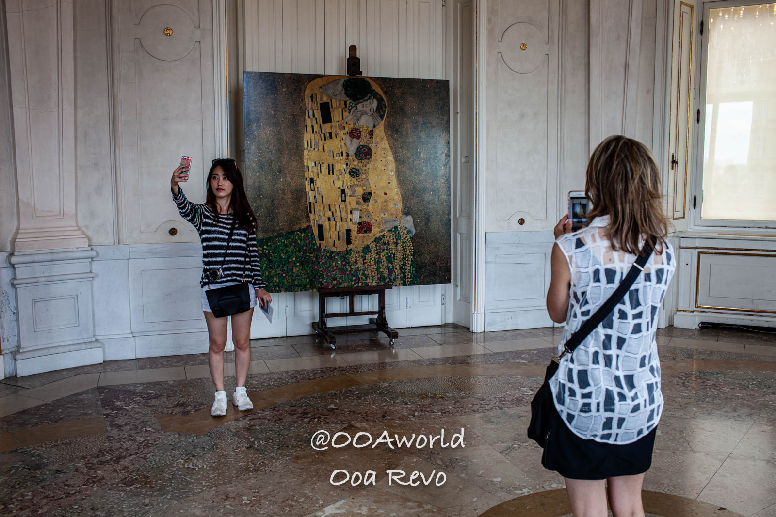 Vienna Austria two people taking photos with Klimt painting in gallery Photo OOAworld