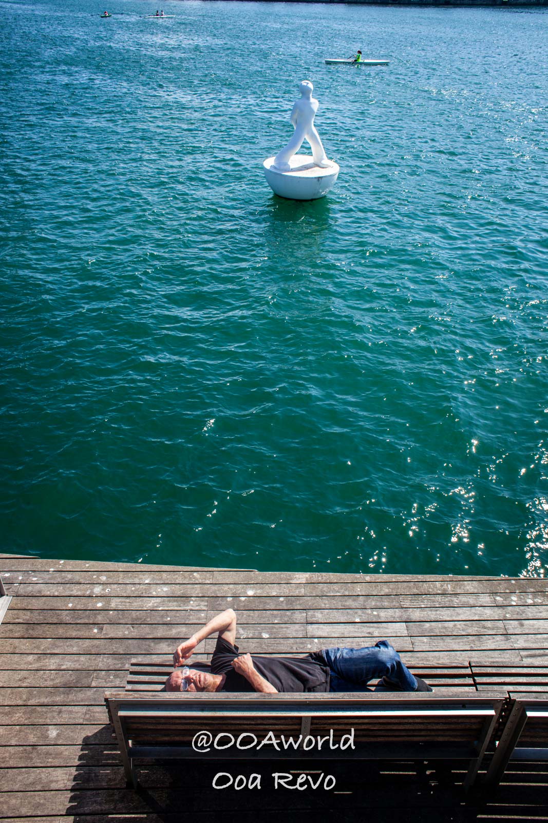 Barcelona Spain man relaxing on dock by water statue Photo OOAworld