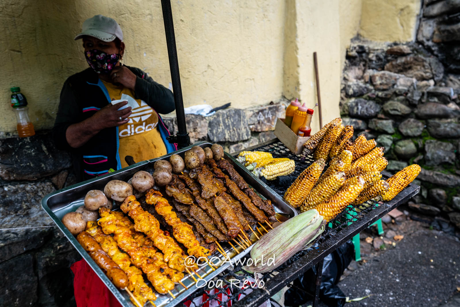 La Candelaria Bogota street food vendor selling grilled corn skewers and potatoes on street Photo OOAworld