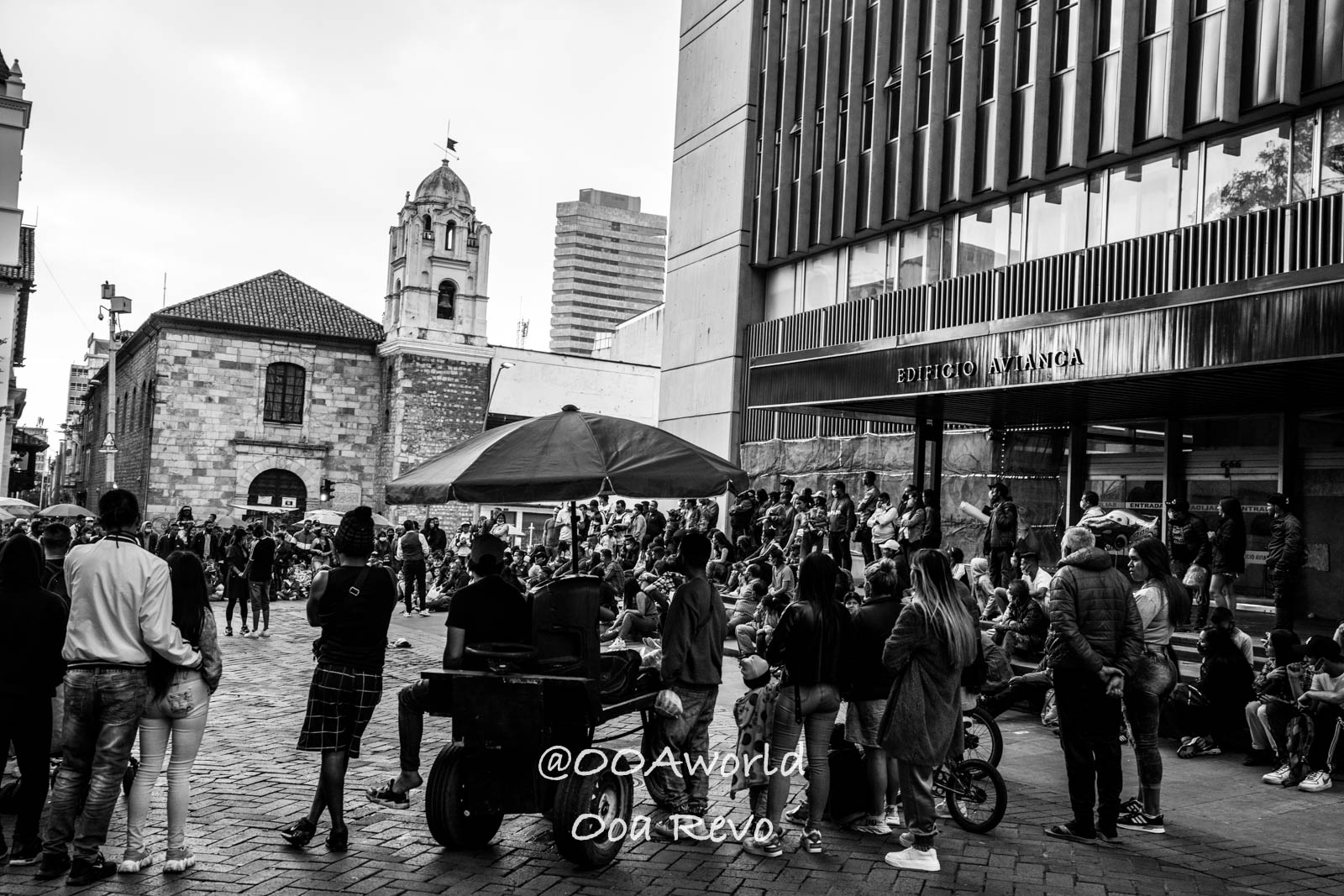 La Candelaria Bogota black and white urban street scene people gathering historical building Photo OOAworld
