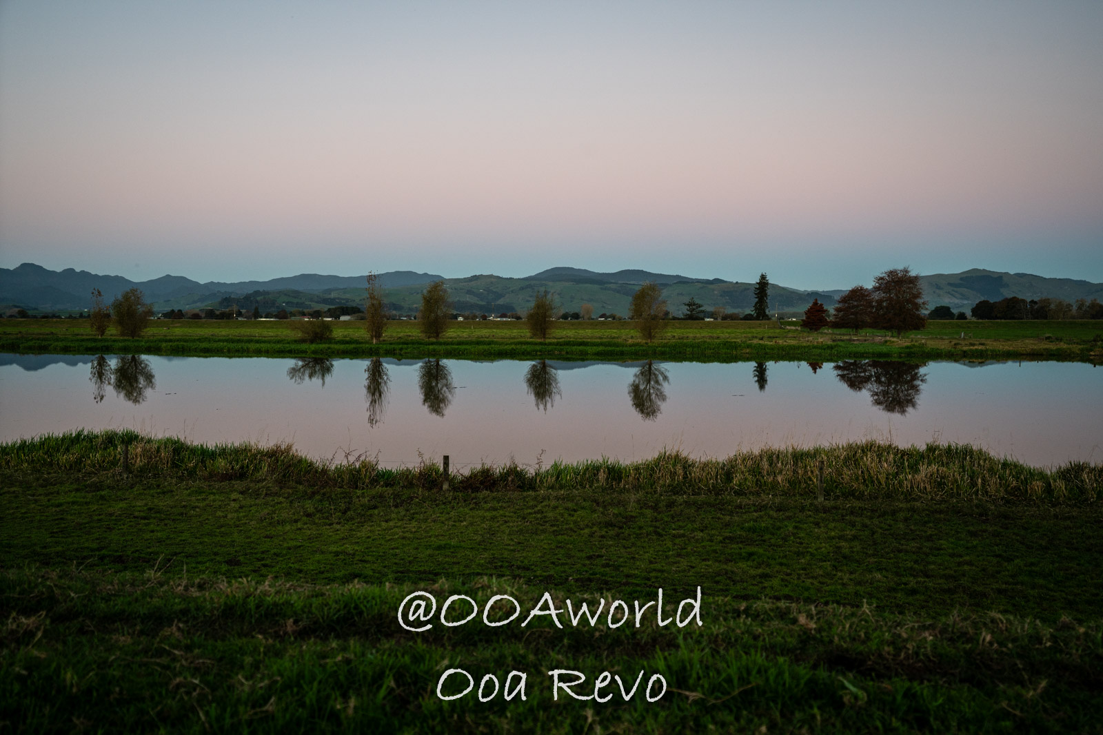 Hobbiton, Coromandel, Auckland New Zealand serene landscape with tree reflections at dusk Photo OOAworld