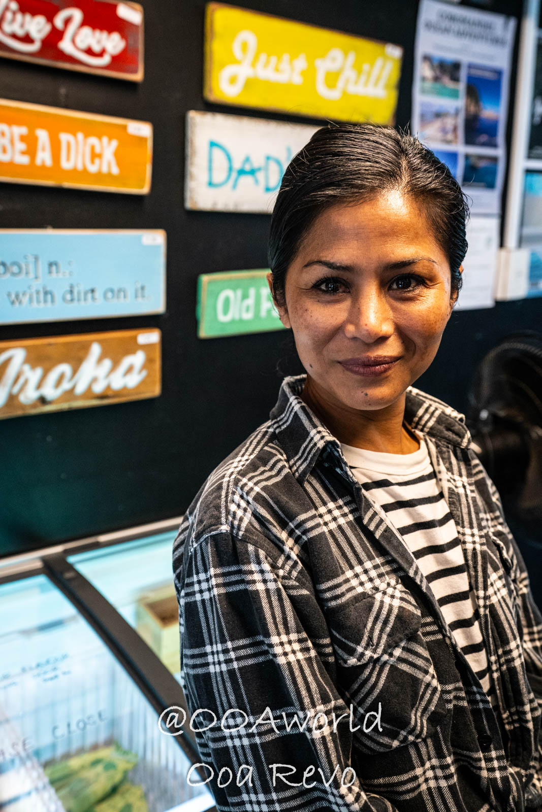 Hobbiton, Coromandel, Auckland New Zealand Person in plaid shirt with colorful wall signs Photo OOAworld