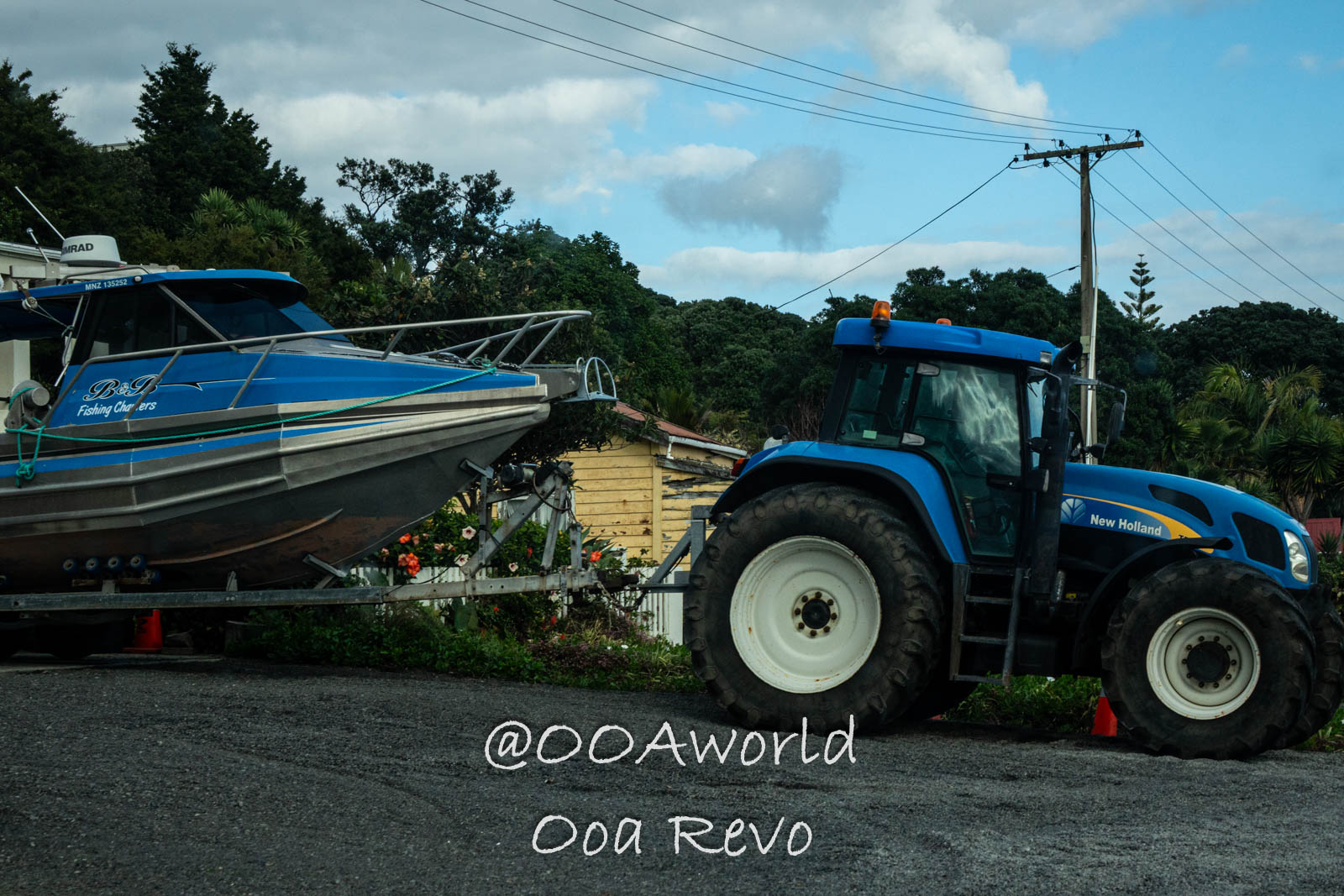 Hobbiton, Coromandel, Auckland New Zealand blue tractor and fishing boat on roadside Photo OOAworld
