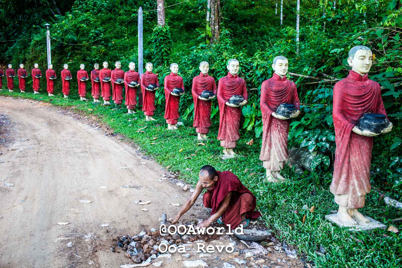 Hpa An Landscapes Hpa An row of monk statues in red robes on lush green path Thailand Photo OOAworld