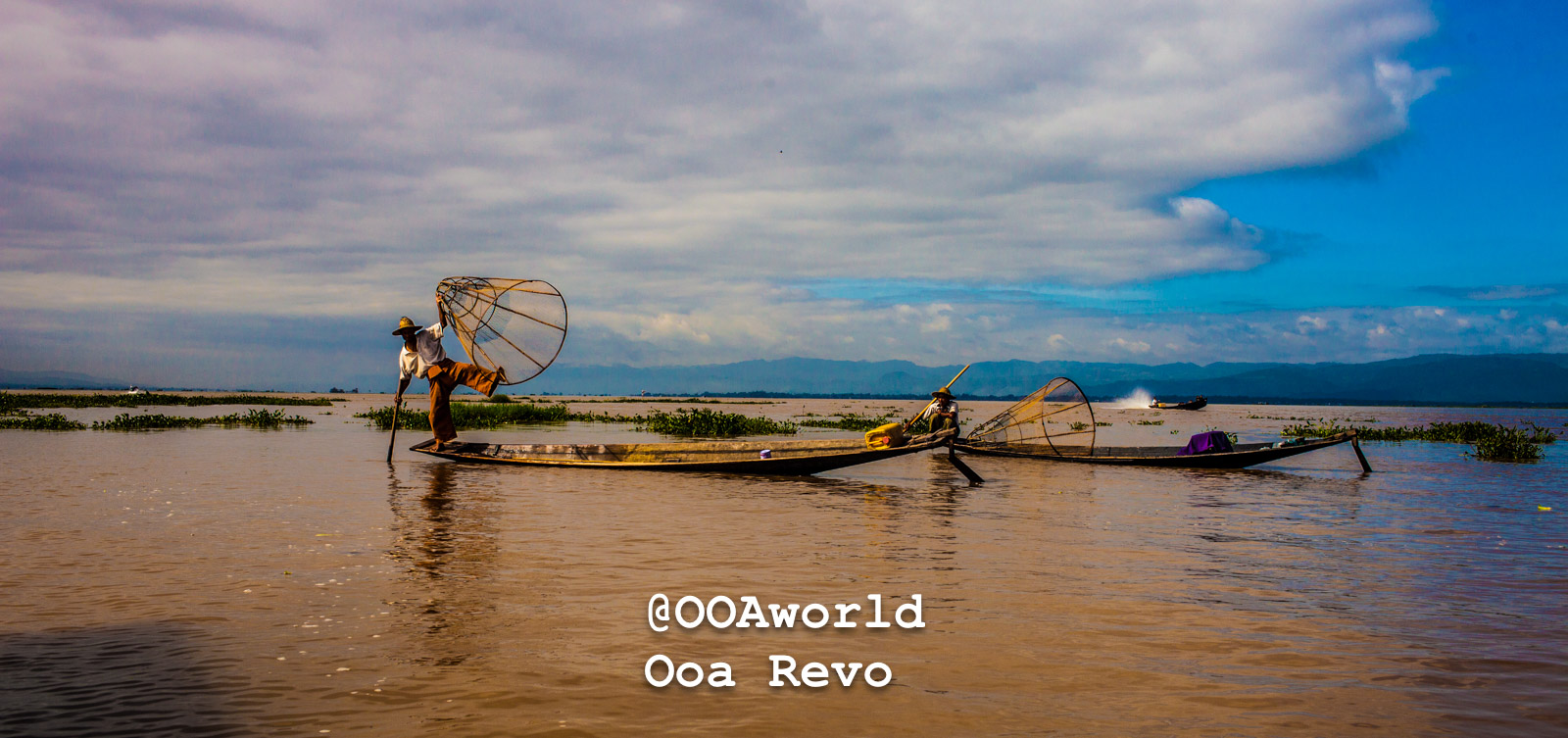 Traditional fishermen on Inle Lake balancing in boats with fishing nets Photo OOAworld