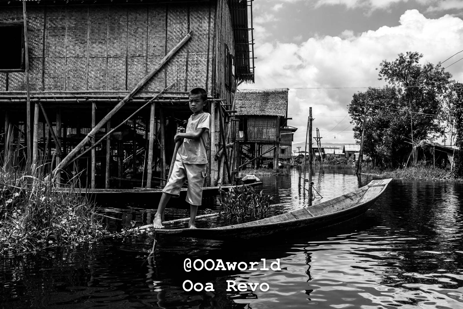 Inle Lake People and Landscape Inle Lake young boy on boat near stilt houses black and white Photo OOAworld
