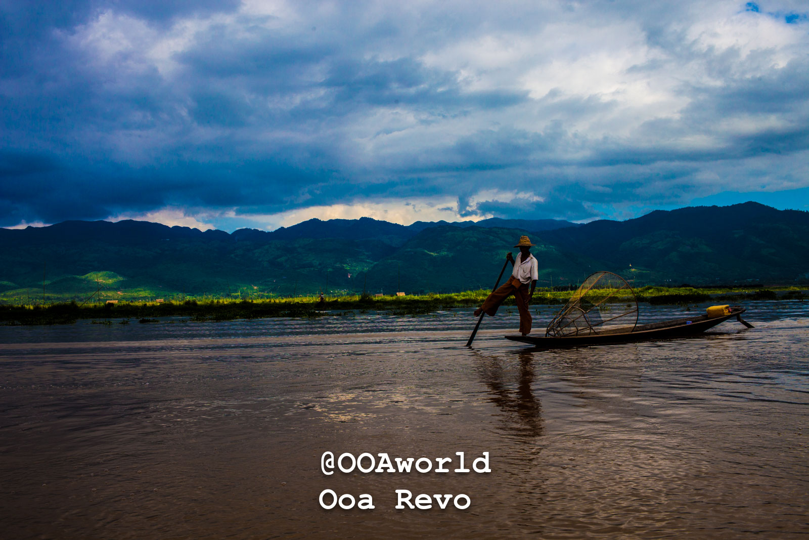 Fisherman balancing on boat in Inle Lake Myanmar dramatic sky Photo OOAworld