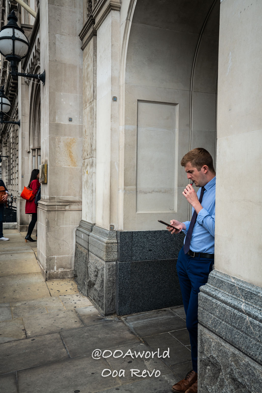 London People and Streets London man leaning on urban building checking phone Photo OOAworld