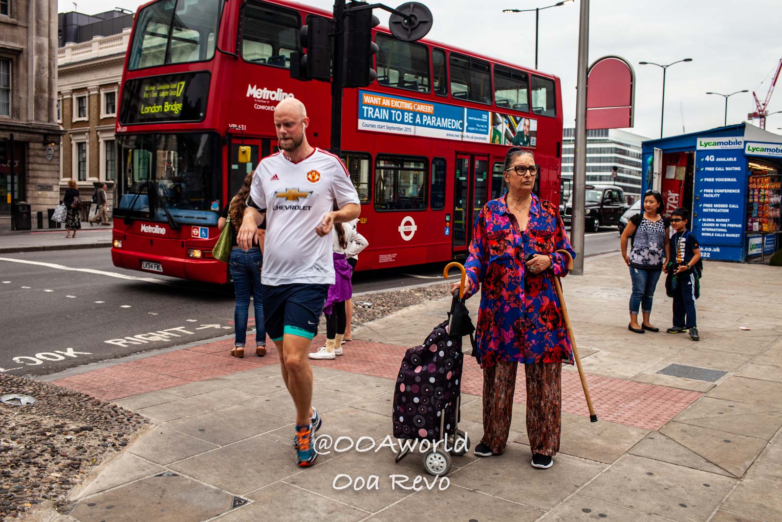 busy London street with red doubledecker bus and pedestrians Photo OOAworld