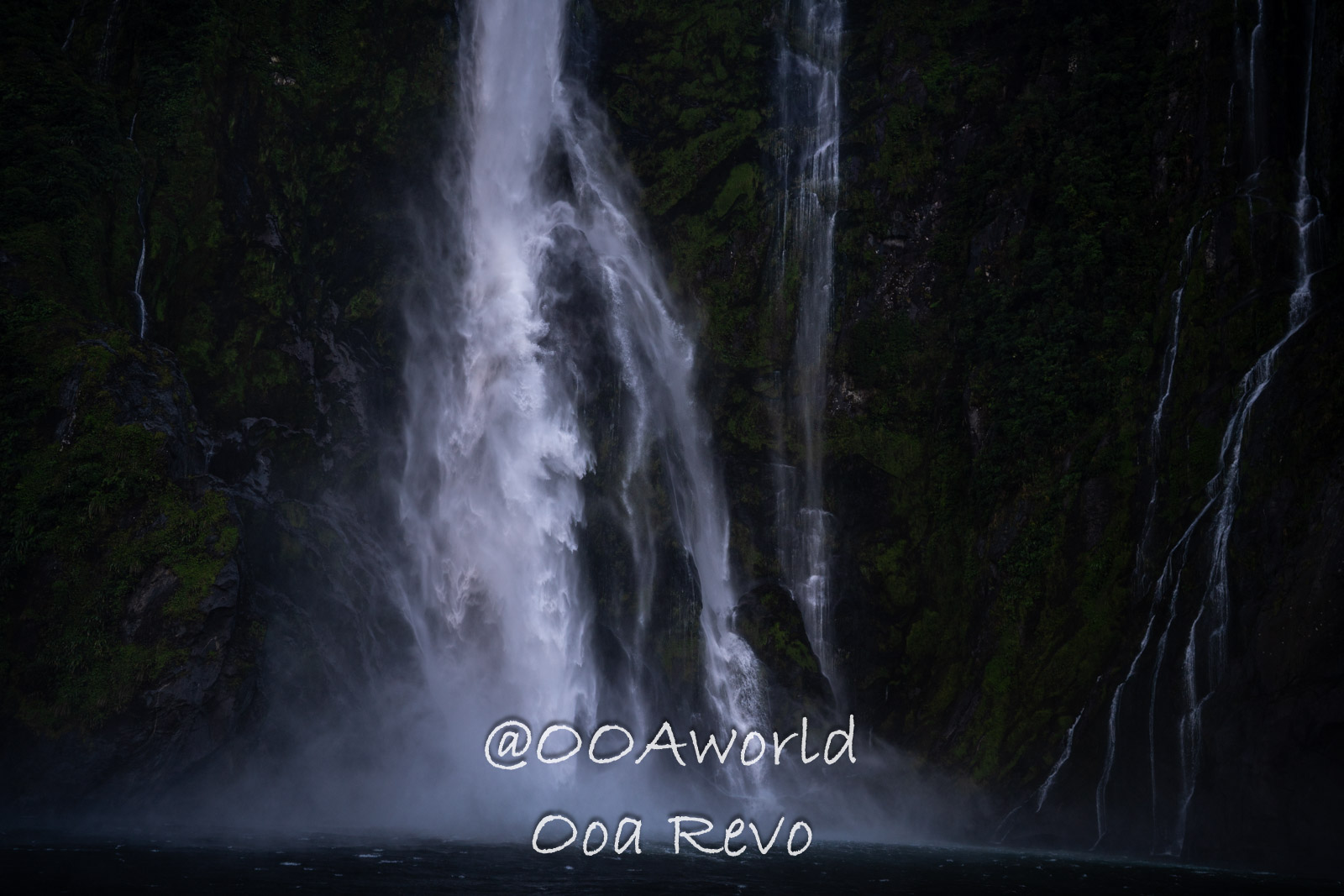Milford Sound Fjord New Zealand powerful waterfall cascading down rocky cliff Photo OOAworld