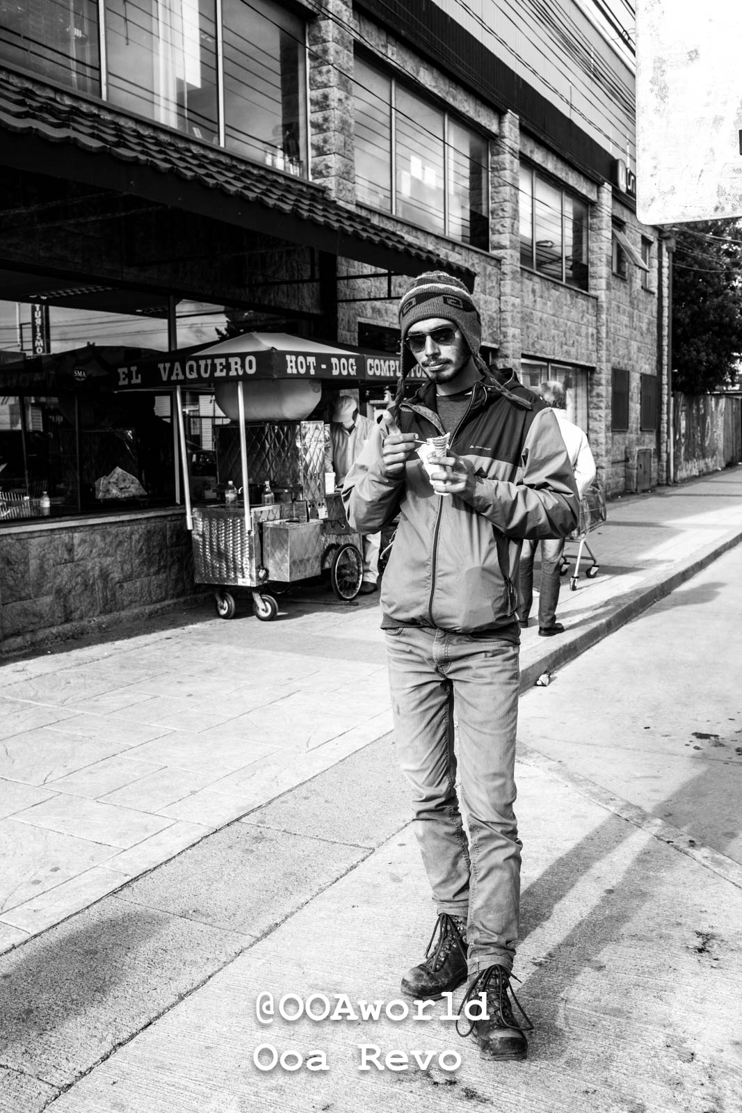 Puerto Natales Post Trek Torres Del Paine Trek man eating ice cream on street black and white Photo OOAworld