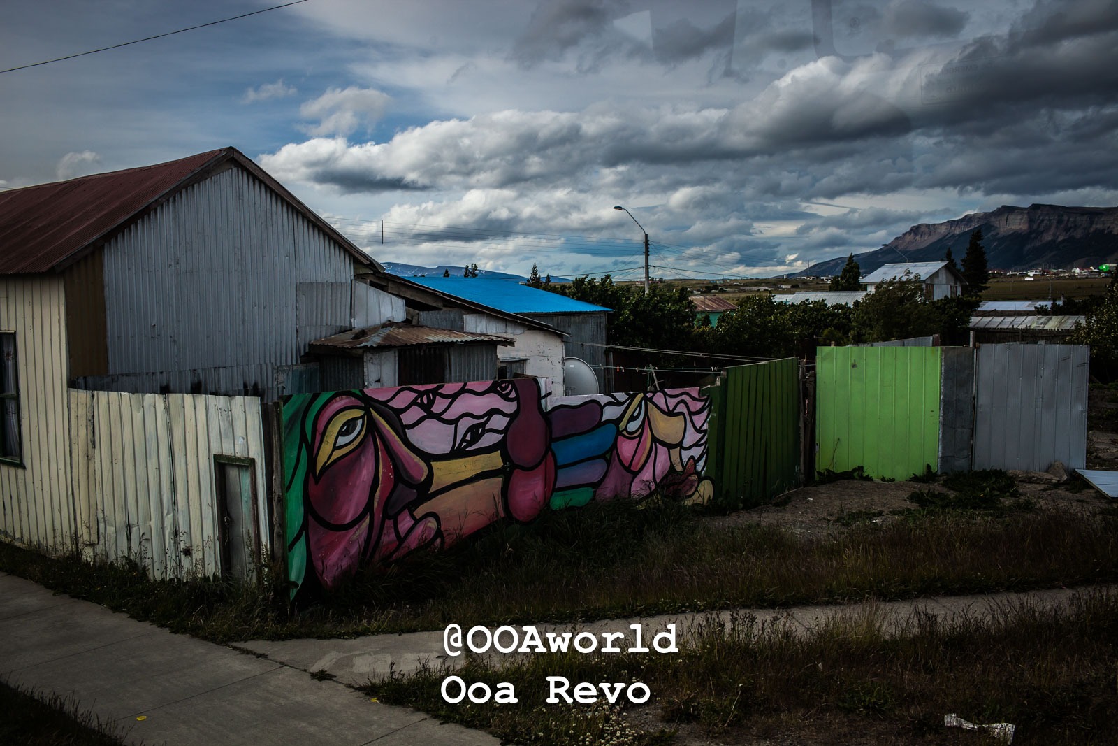 Puerto Natales Post Trek Torres Del Paine Trek Colorful mural on a rustic building with mountains in background Photo OOAworld
