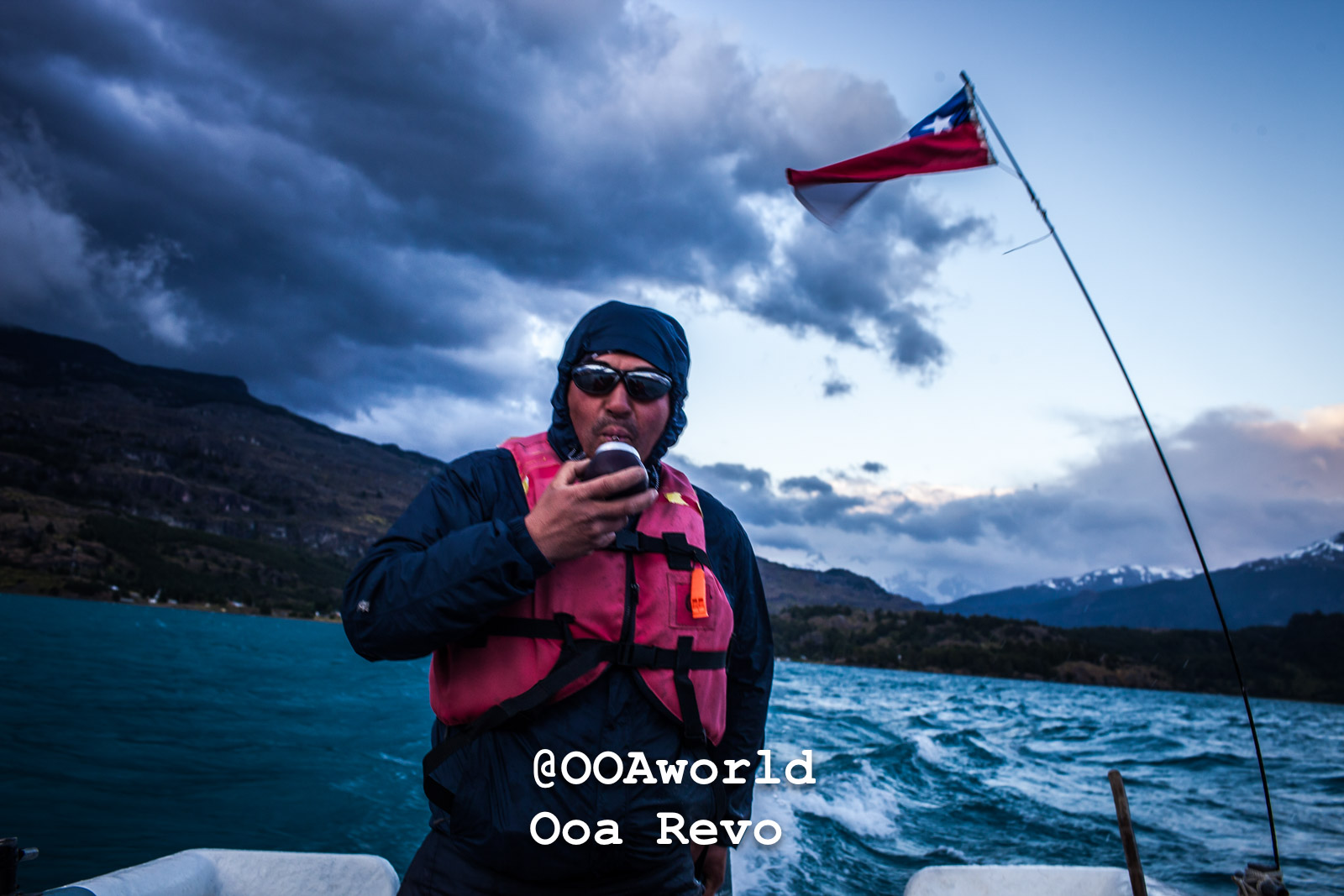 Puerto Rio Tranquilo People and Landscapes Puerto Rio Tranquilo OOAworld adventurer on boat with Chilean flag and stormy sky Photo OOAworld
