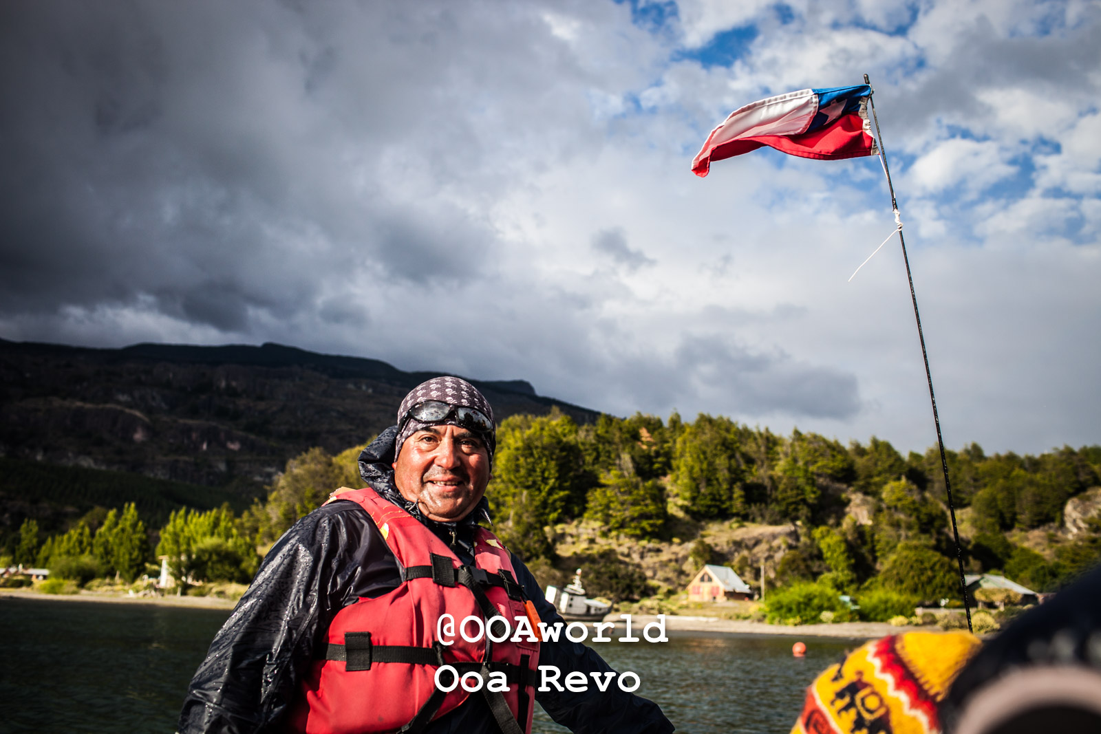 Puerto Rio Tranquilo People and Landscapes Puerto Rio Tranquilo OOAworld Chilean boater in life jacket with flag and scenic backdrop Photo OOAworld