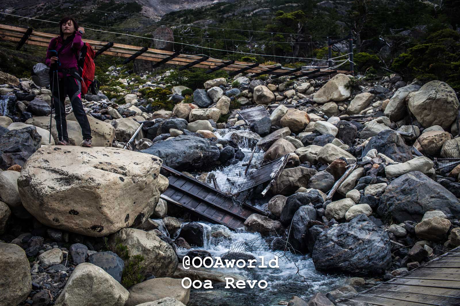 Torres Del Paine Day 3 Torres Del Paine Trek Hiker on rocky trail with bridge in background Photo OOAworld