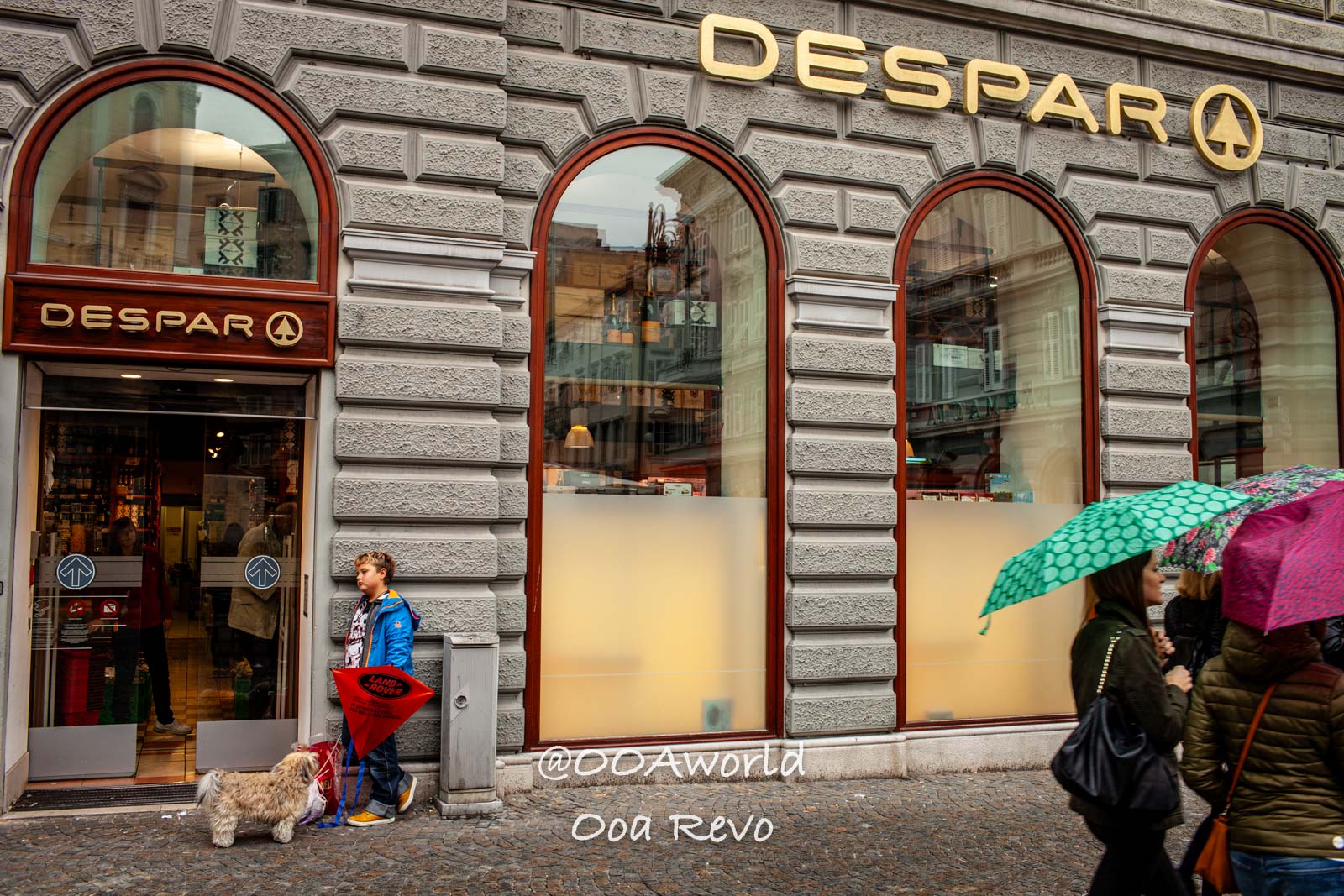 Trieste Italy urban scene outside Despar store with people and umbrellas Photo OOAworld