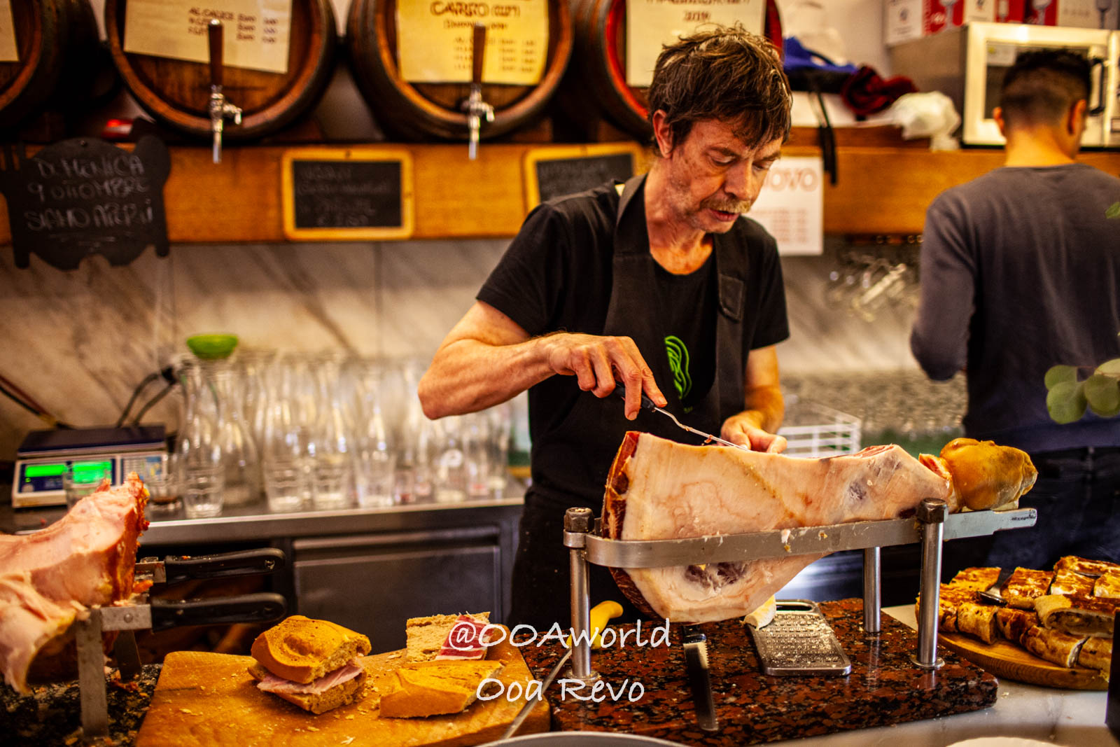Trieste Italy man slicing cured ham in Italian deli Photo OOAworld