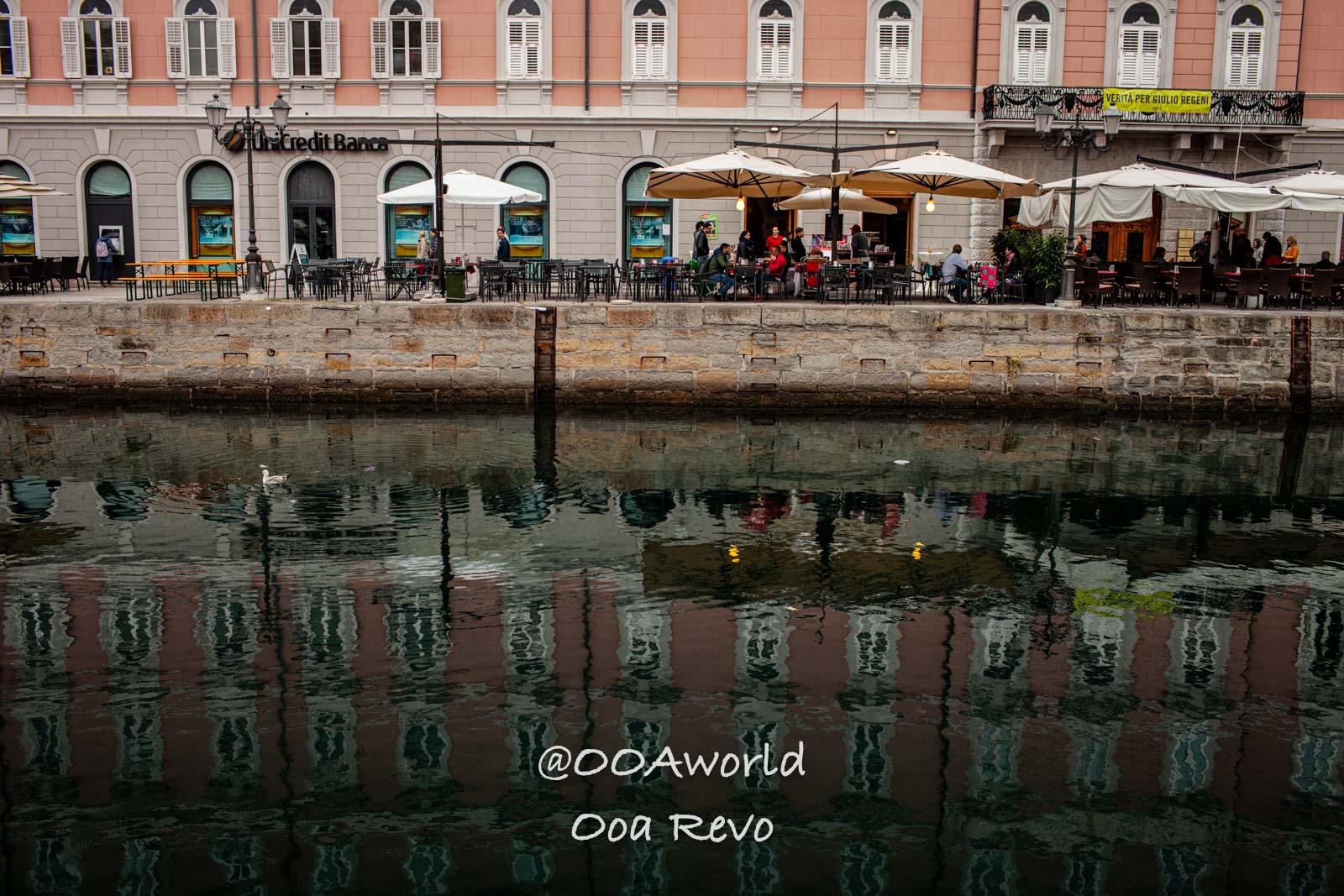 Trieste Italy canal side cafe with umbrellas and reflections Photo OOAworld