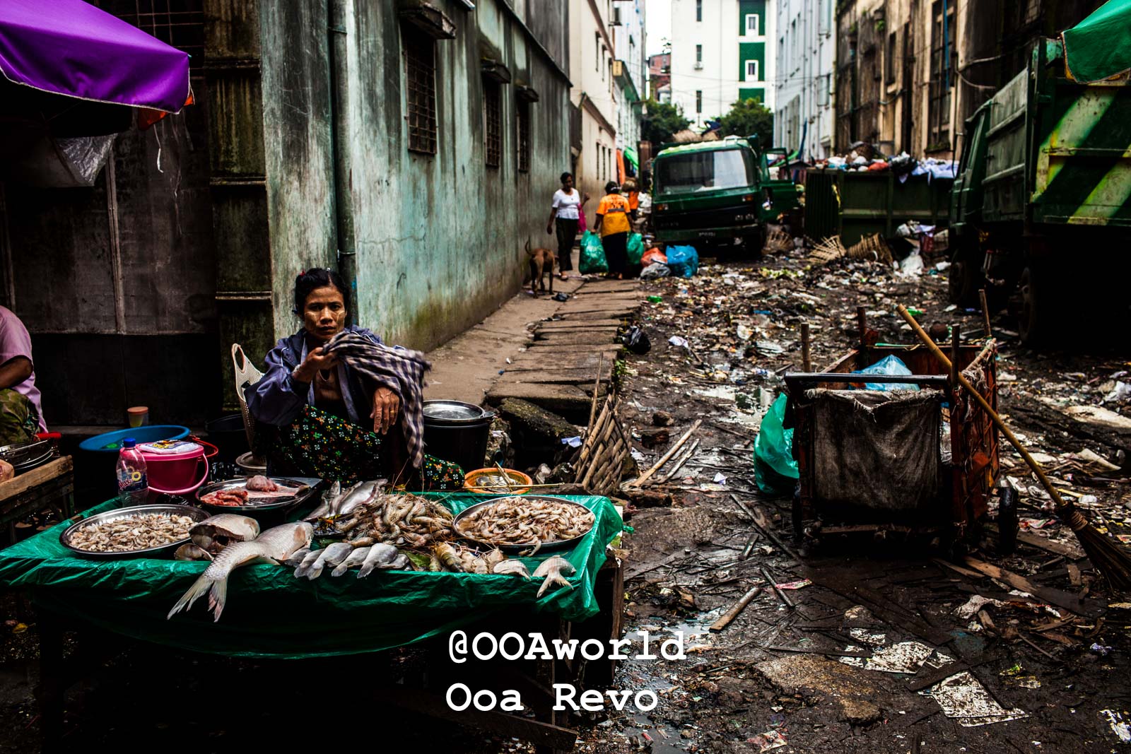 Yangon People and Streets Yangon street market vendor in urban alleyway surrounded by waste Photo OOAworld
