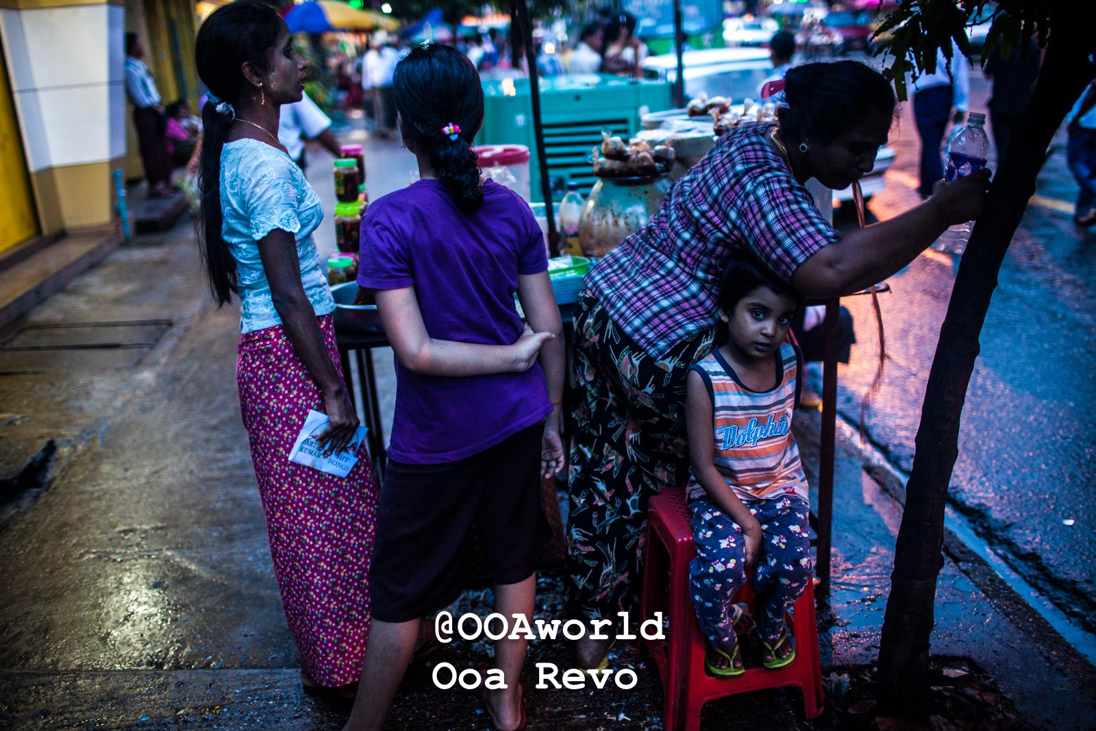 Yangon People and Streets Yangon street market scene with vendors and child at dusk Photo OOAworld