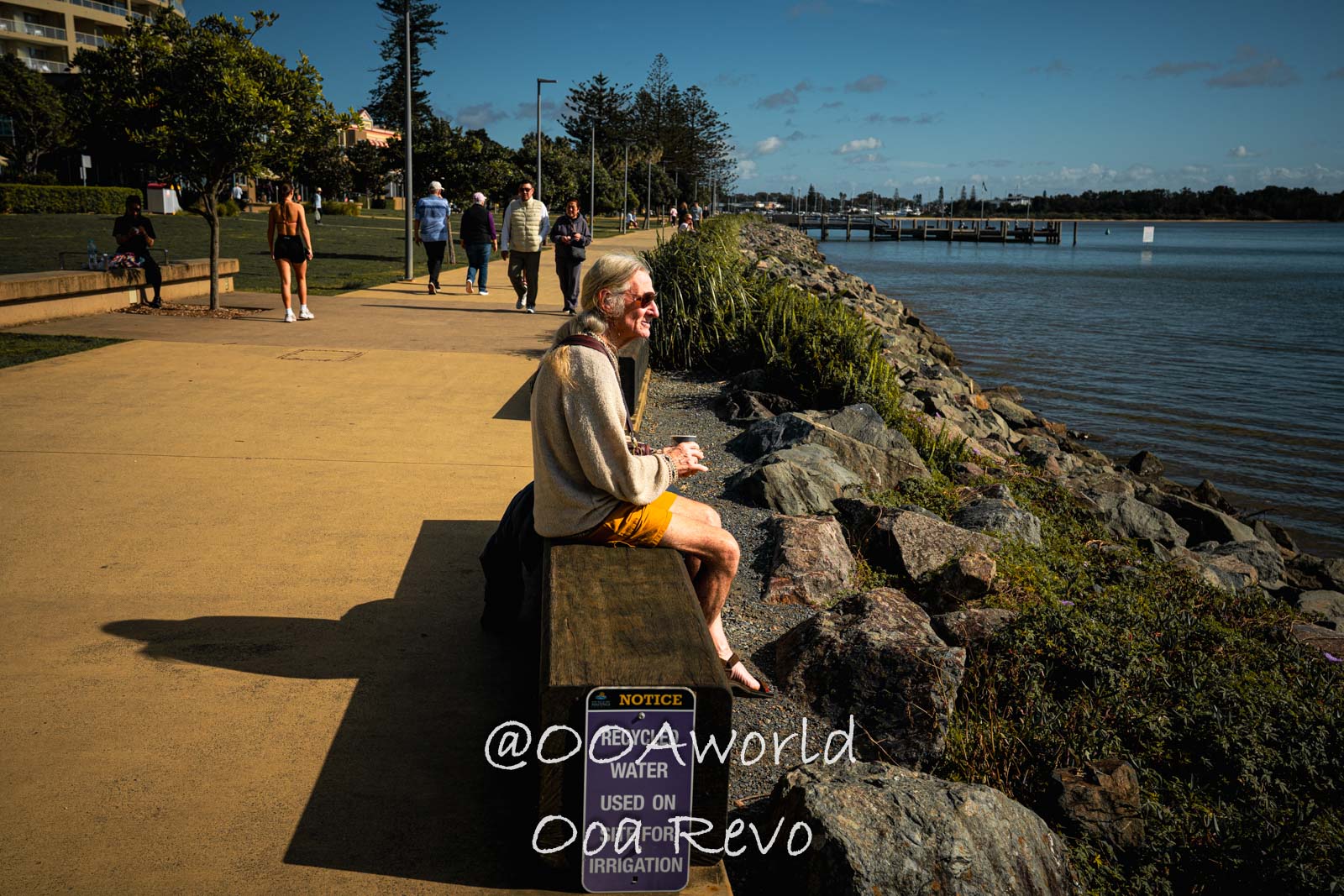 Byron Bay, Port Macquarie Australia elderly man sitting by waterfront path Photo OOAworld