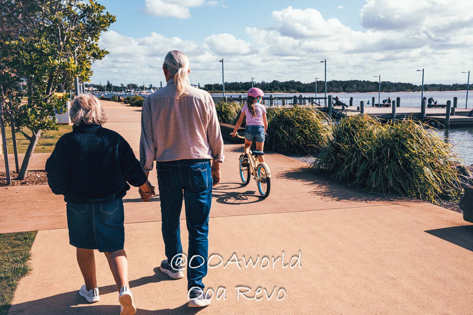 Byron Bay, Port Macquarie Australia family walking and biking along waterfront path Photo OOAworld