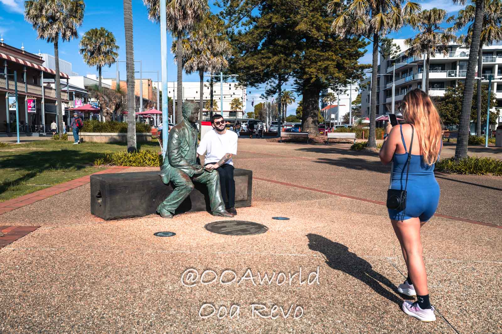 Byron Bay, Port Macquarie Australia tourist photographing bronze statue on sunny street Photo OOAworld