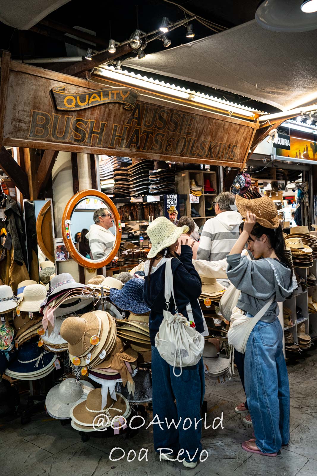 Shoppers exploring hats in Australian market Photo OOAworld