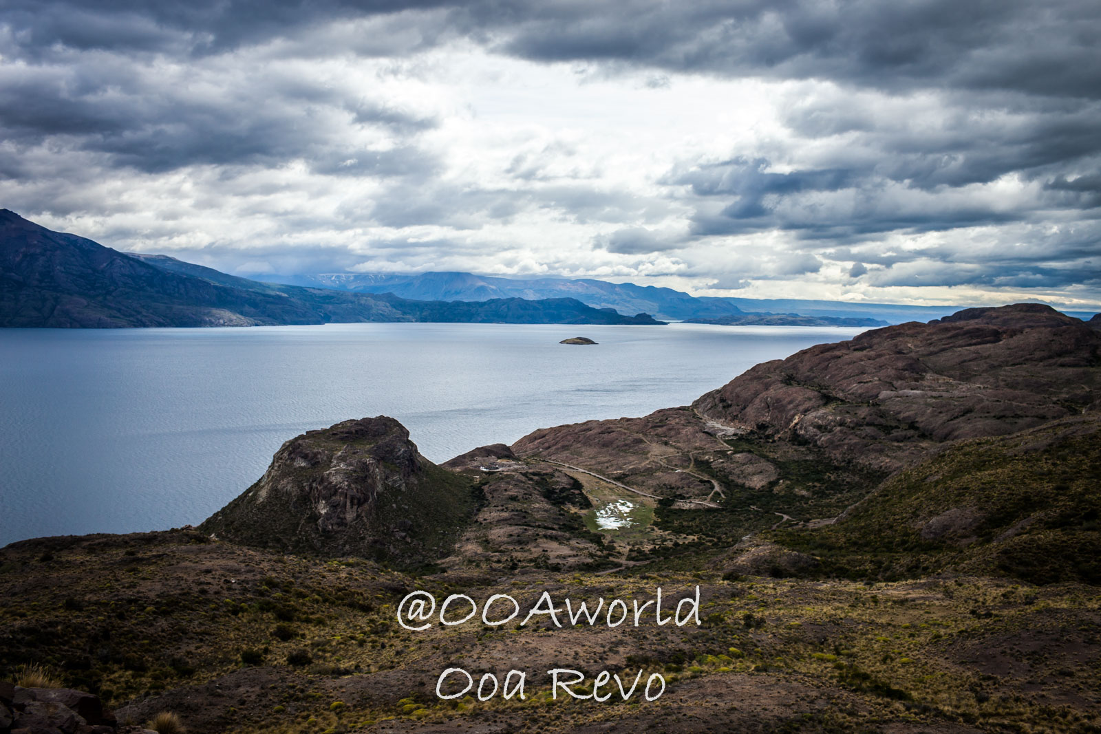 Bus Chile Chico to Puerto Rio Tranquilo Landscapes Chile Chico Scenic view of expansive lake and mountain landscape under cloudy sky Photo OOAworld