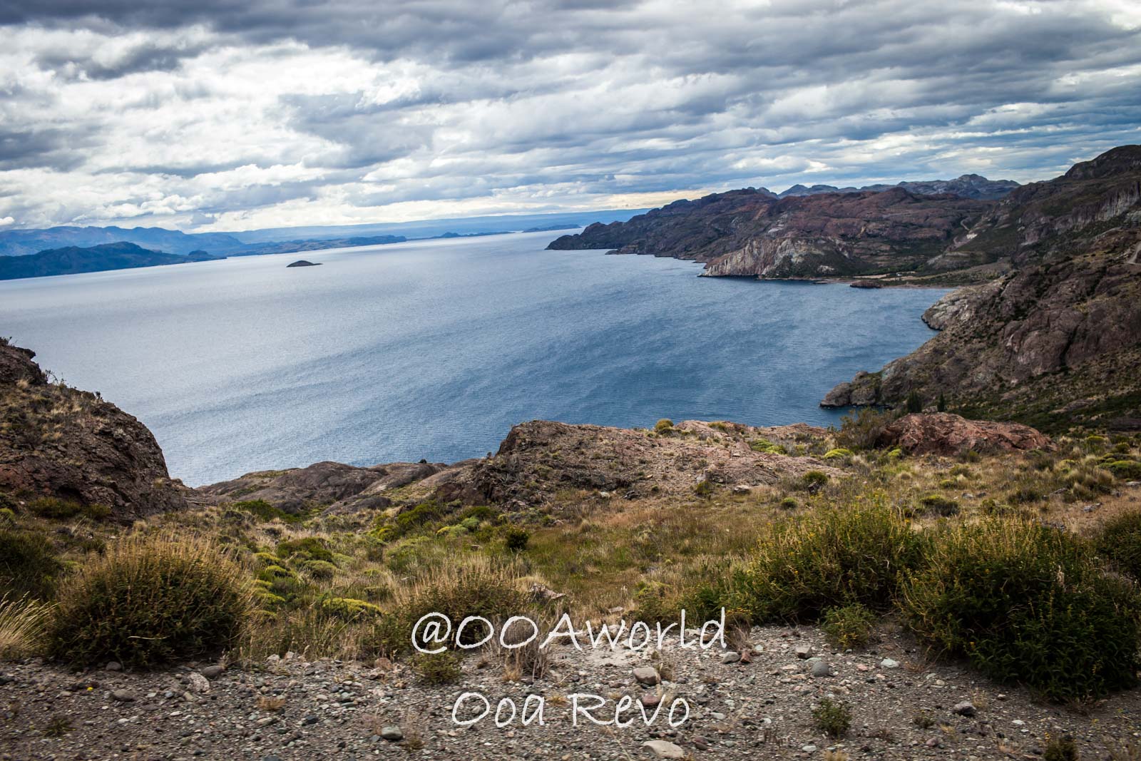 Bus Chile Chico to Puerto Rio Tranquilo Landscapes Chile Chico Scenic view of a rocky coastline and expansive blue lake under a cloudy sky Photo OOAworld