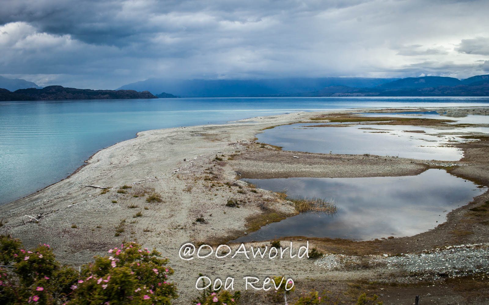Bus Chile Chico to Puerto Rio Tranquilo Landscapes Chile Chico Panoramic view of serene lake with cloudy sky and sandy shore Photo OOAworld