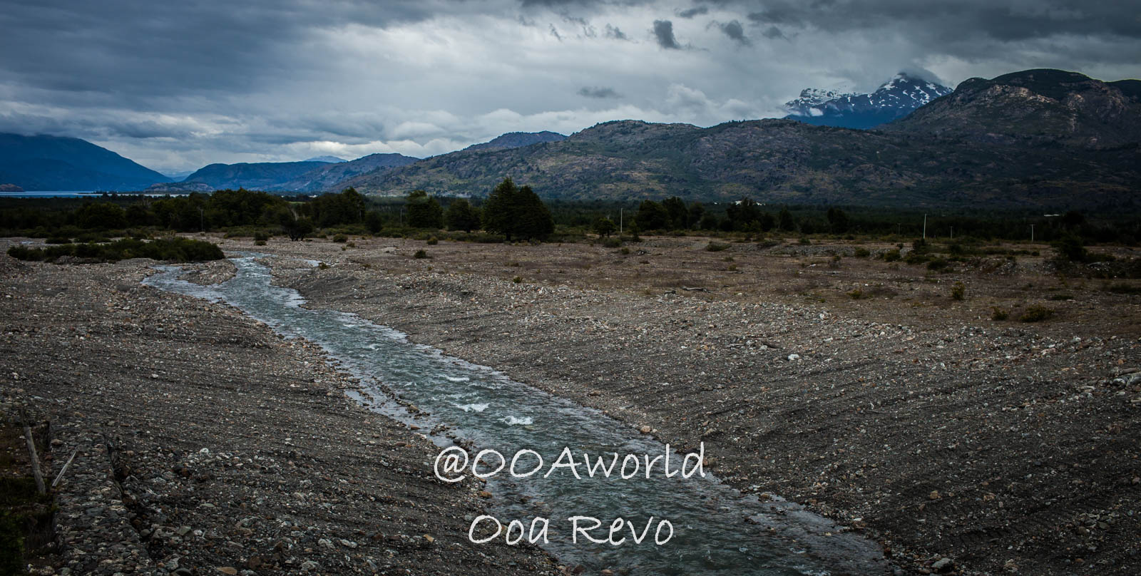 Bus Chile Chico to Puerto Rio Tranquilo Landscapes Chile Chico Mountain landscape with winding stream under cloudy sky Photo OOAworld
