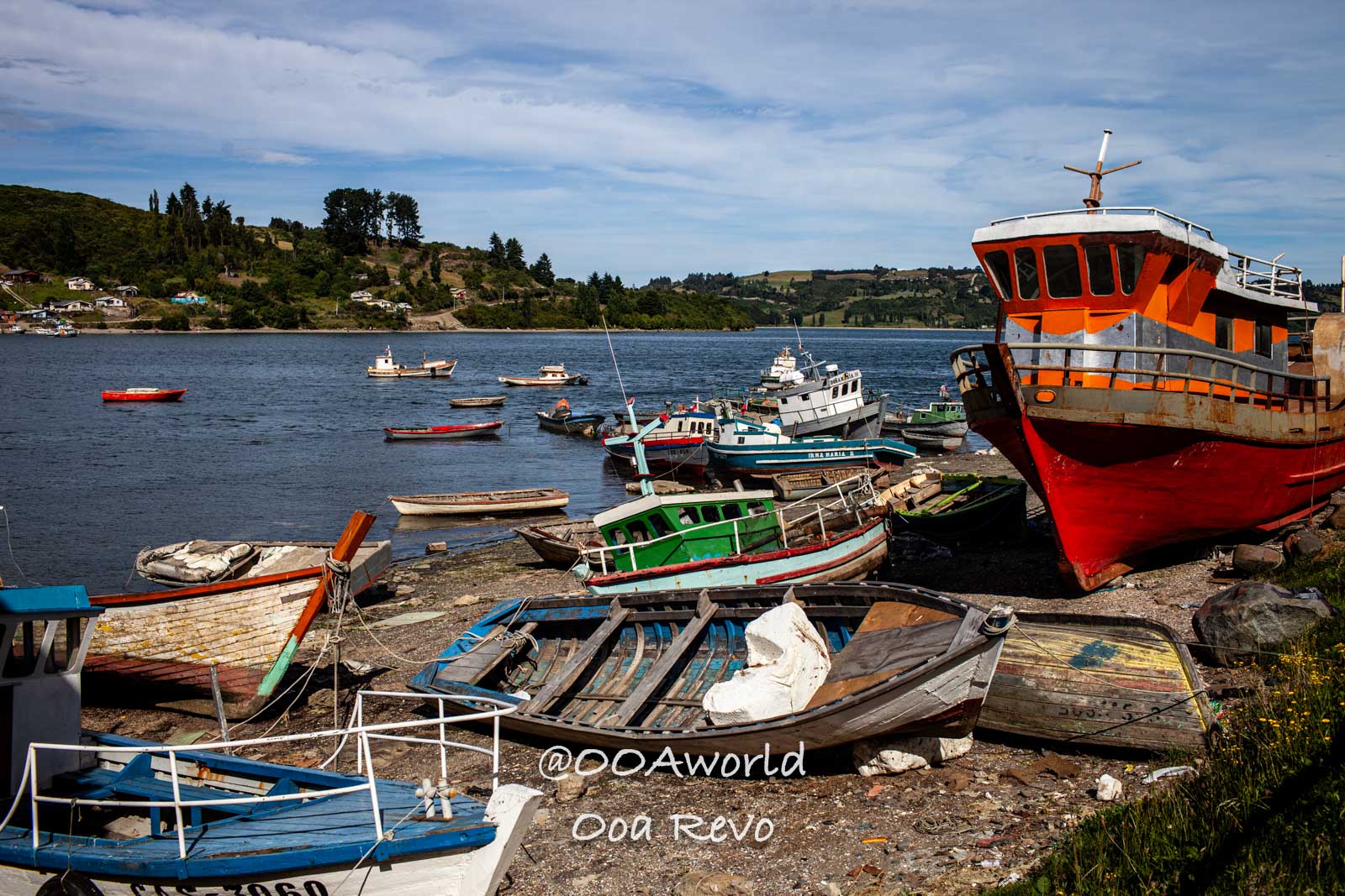 Palafitos and NYE Chiloe colorful boats on shore lake Photo OOAworld