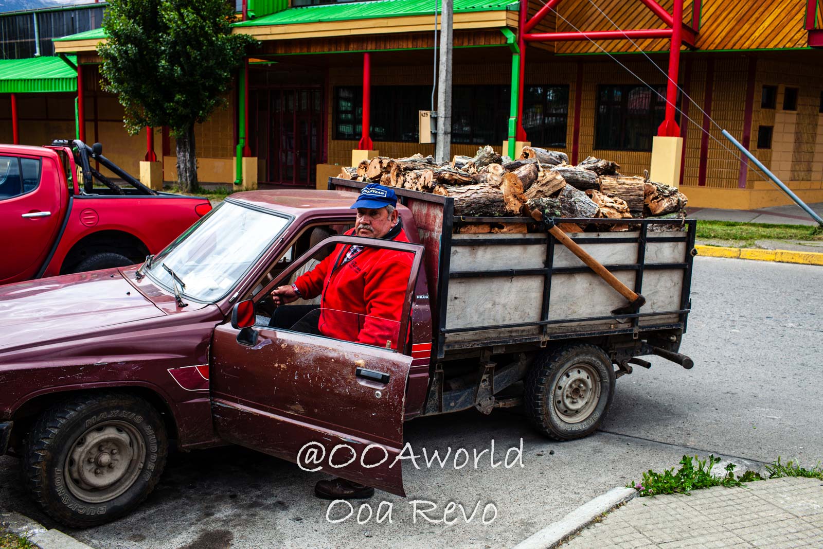People and Streets Coyhaique man driving truck loaded with firewood Photo OOAworld