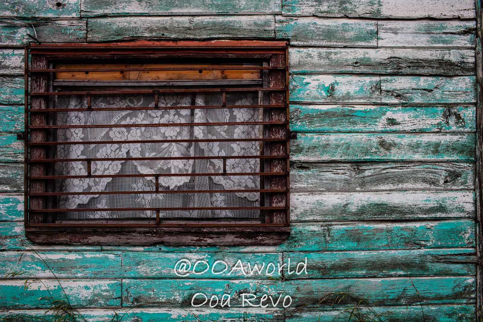 People and Streets Coyhaique rustic window with lace curtains and peeling green paint Photo OOAworld