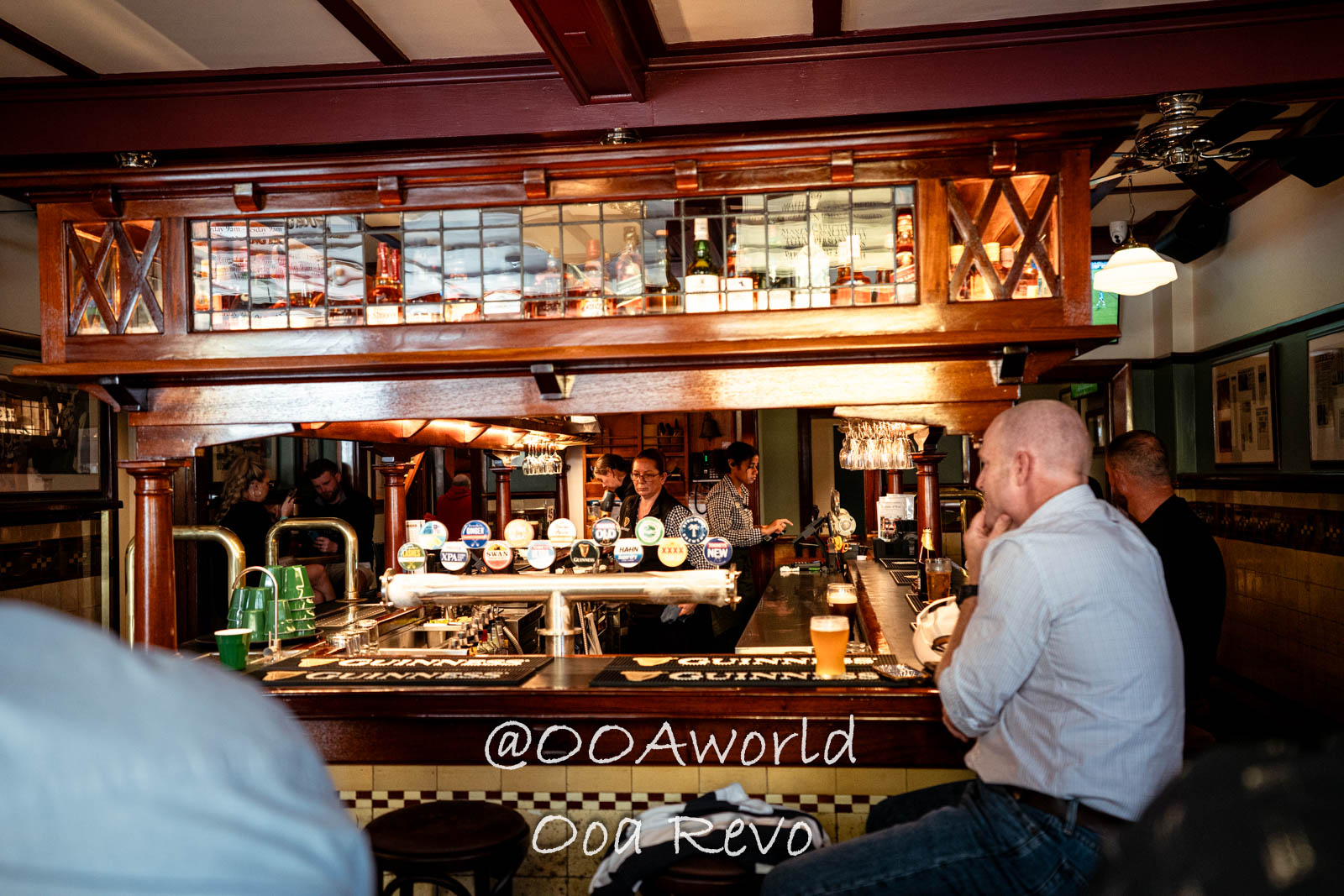 Old Sydney Sydney Traditional Pub Interior with Patrons Photo OOAworld Old Sydney Sydney cozy traditional pub with patrons enjoying drinks near a wooden bar Photo OOAworld
