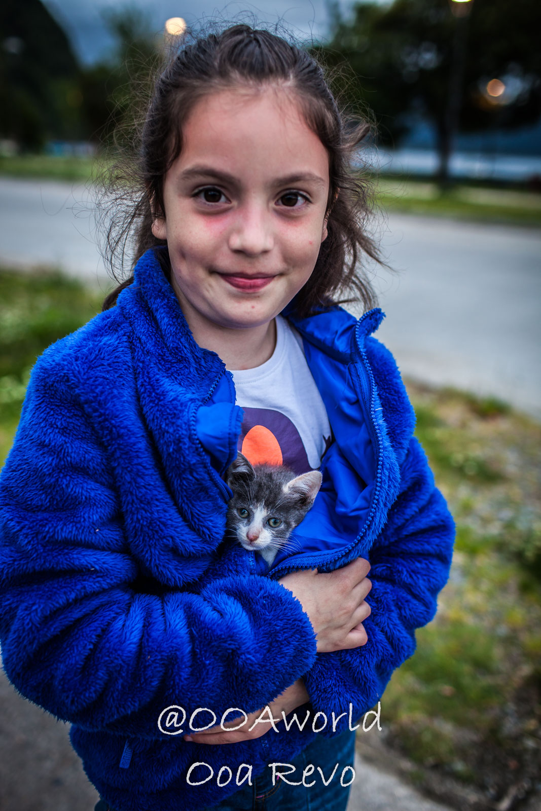 People Portraits Streets Puerto Cisnes girl in blue jacket holding kitten Photo OOAworld