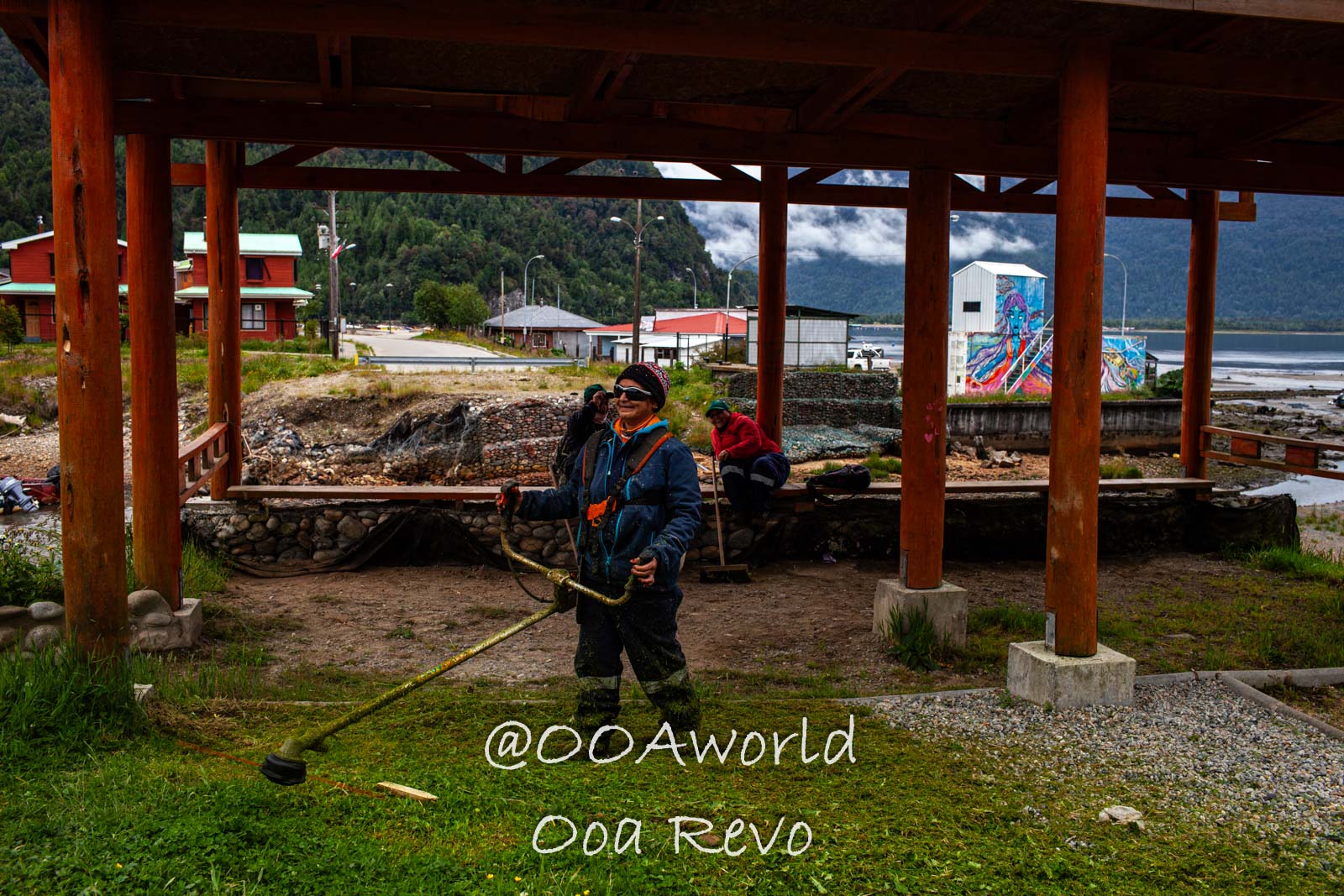 People Portraits Streets Puerto Cisnes man using grass trimmer in rural pavilion Photo OOAworld