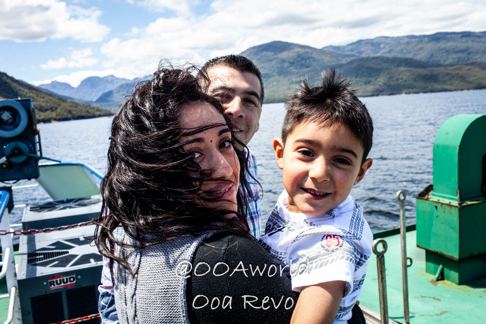 People Portraits Streets Puerto Cisnes family on boat with mountain views Photo OOAworld