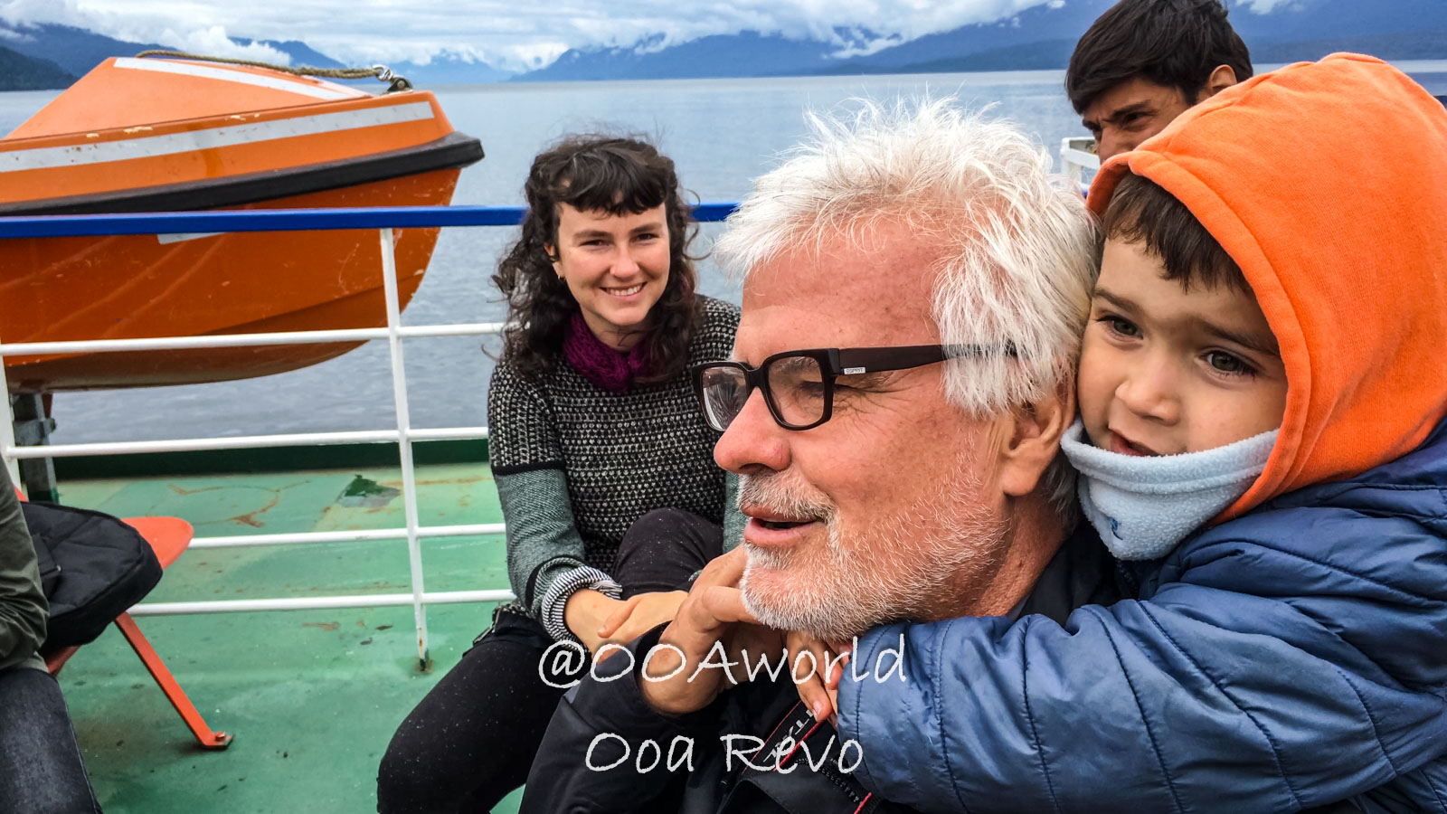People Portraits Streets Puerto Cisnes family on ferry with lake and mountains Photo OOAworld
